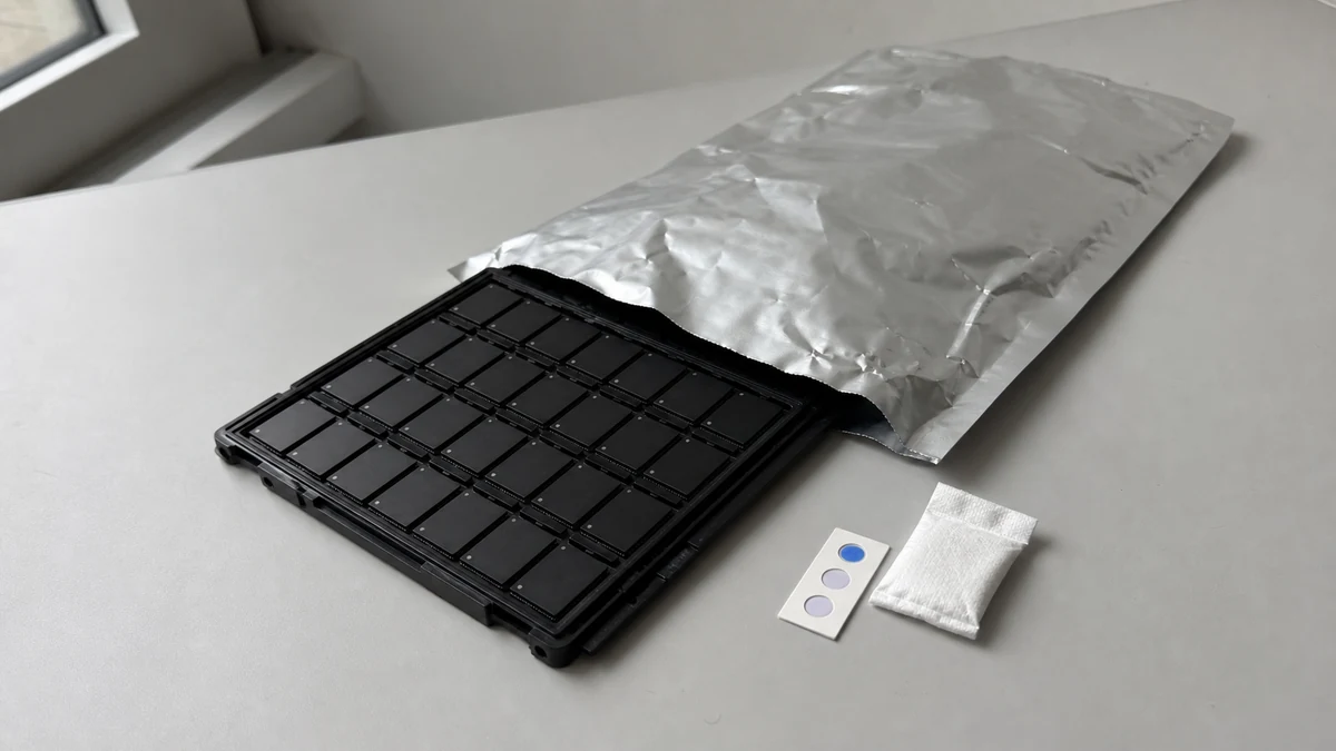 eMMC BGA components in a JEDEC tray beside moisture-barrier packaging, desiccant and a humidity indicator